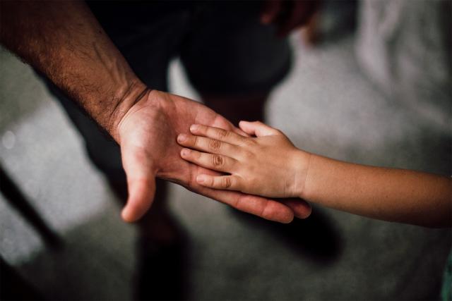 Photo of hand of child and adult