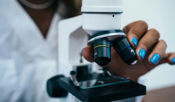 Photo of hand holding microscope