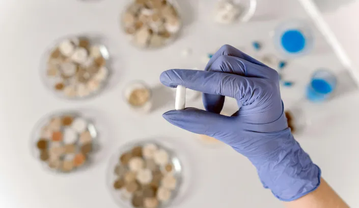 Foto av en hand med handske som håller i labb utrustning